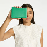 Status Anxiety Gone Again Wallet in Emerald Nappa leather, showcasing its sleek design and vibrant green color.