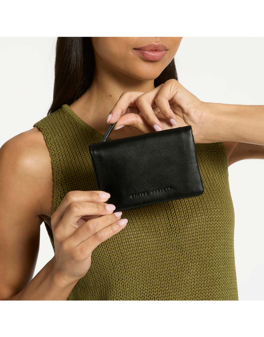 Black Status Anxiety Is Now Better Wallet with multiple card slots and sleek design, shown with lifestyle imagery.