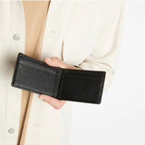 Black Status Anxiety Jonah Wallet with multiple card slots and sleek leather design, shown on a lifestyle background.