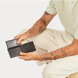 Status Anxiety Jonah Wallet in chocolate leather, featuring multiple card slots and a sleek, compact design.