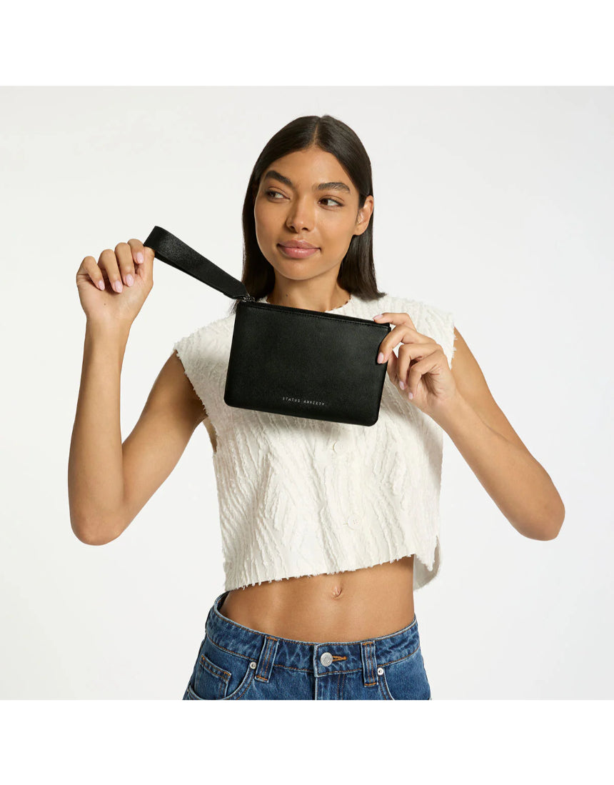 Black Status Anxiety Take Your Chances wallet with multiple card slots and a sleek design, shown in a lifestyle setting.