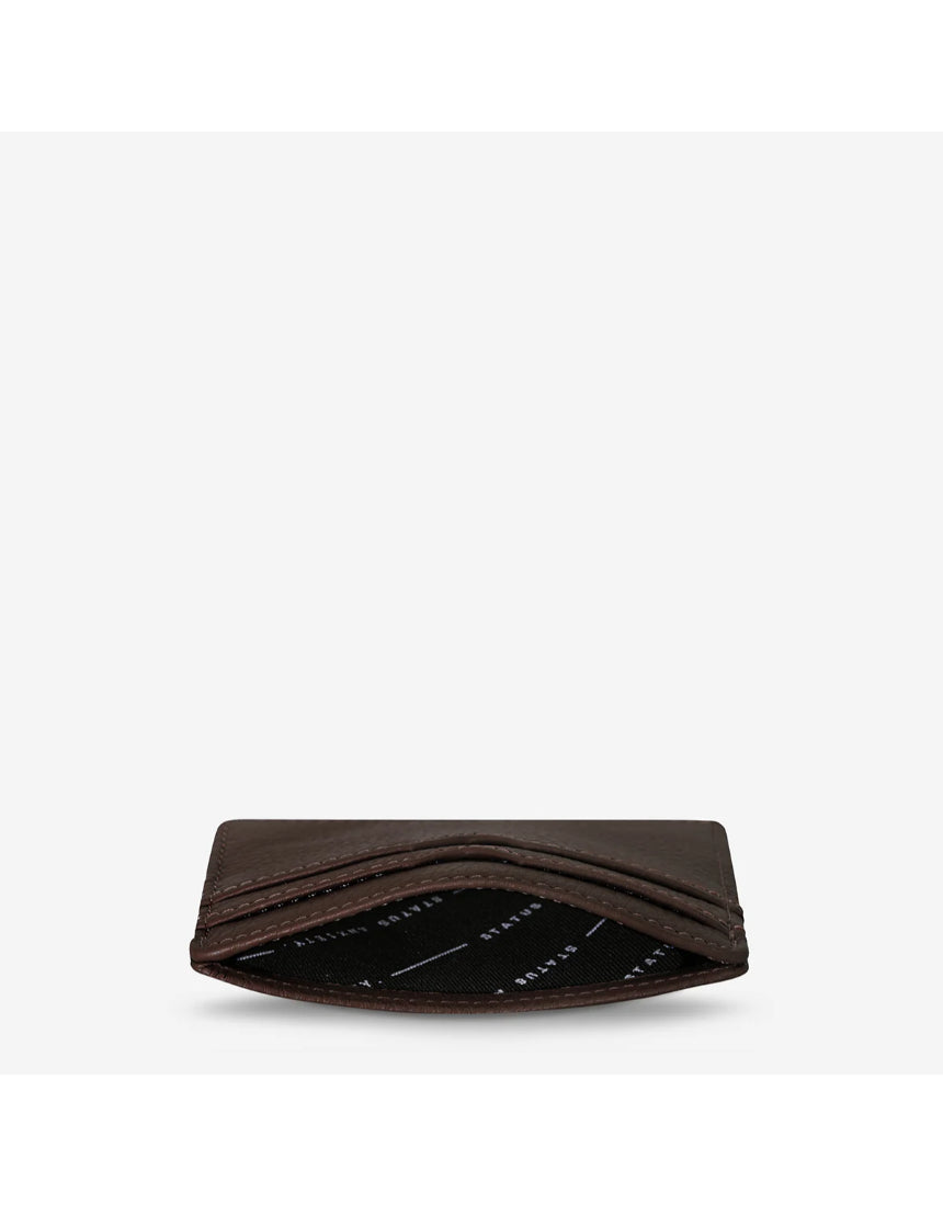 Status Anxiety Together For Now Cocoa wallet, top-angle view showing compact brown leather design and silver hardware details.