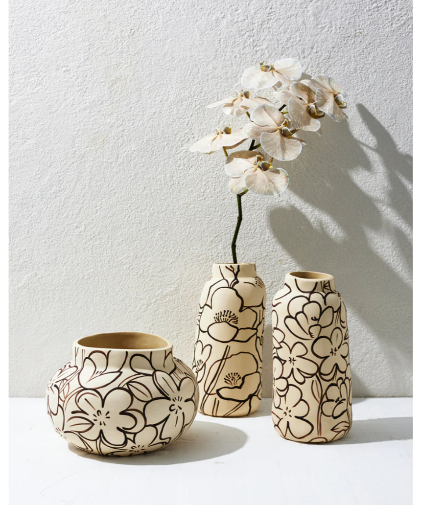 Jones & Co Tender Poppy tall vase with a sleek, modern design, displayed on a stylish surface with decorative flowers inside.