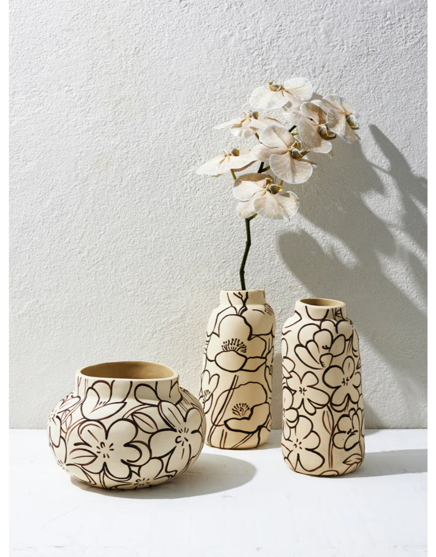 Jones & Co Tender Poppy tall vase with a sleek, modern design, displayed on a stylish surface with decorative flowers inside.