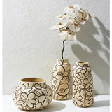 Jones & Co Tender Poppy tall vase with a sleek, modern design, displayed on a stylish surface with decorative flowers inside.