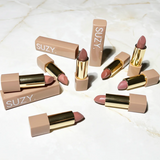 Suzy Lipsticks Chestnut Matte lipstick displayed with a rich brown shade and sleek packaging.
