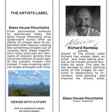The Artists Label Glass House Mountains scarf featuring a scenic mountain design on soft fabric, displayed hanging with a tag.