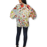 Back view of The Artists Label Julie’s Garden silk kimono with floral patterns and flowing fabric.
