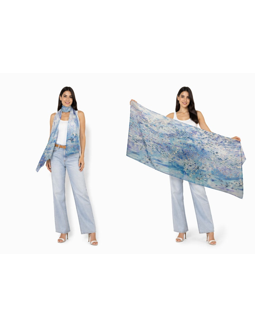 The Artists Label viscose modal scarf featuring a "Swept Beneath the Sea" design with ocean-inspired patterns in blue and white.