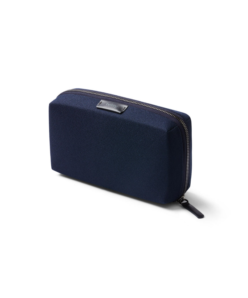 Bellroy Tech Kit in navy with multiple compartments and zippers, designed for organizing tech accessories and cables.