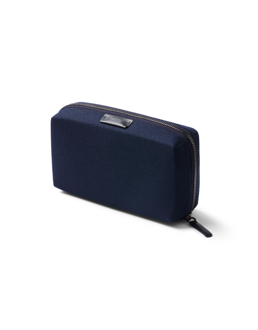 Bellroy Tech Kit in navy with multiple compartments and zippers, designed for organizing tech accessories and cables.