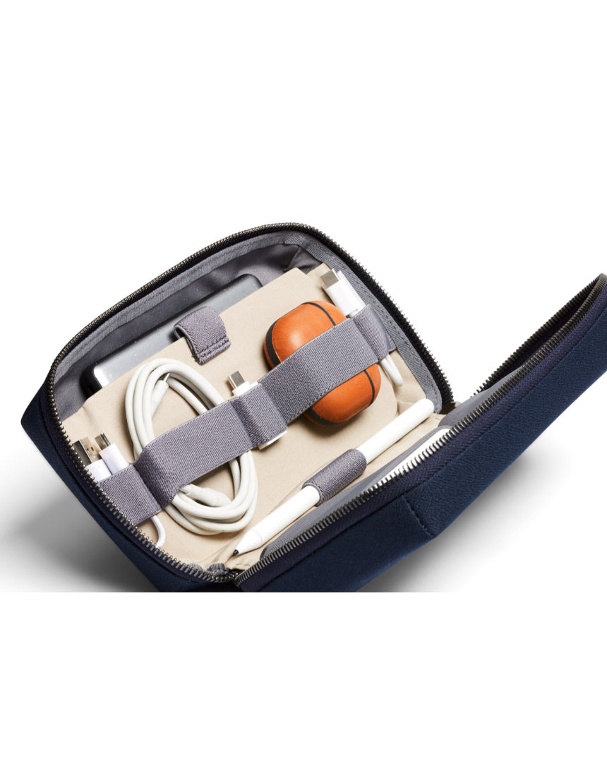 Bellroy Tech Kit in navy with multiple compartments and zippers, designed for organizing cables, chargers, and tech accessories.