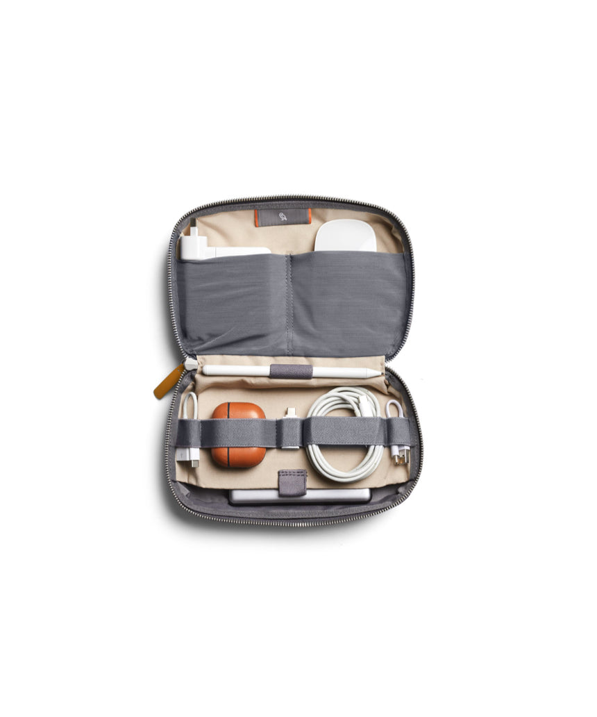Bellroy Tech Kit in slate color, showing organized interior with multiple compartments for cables, chargers, and accessories.