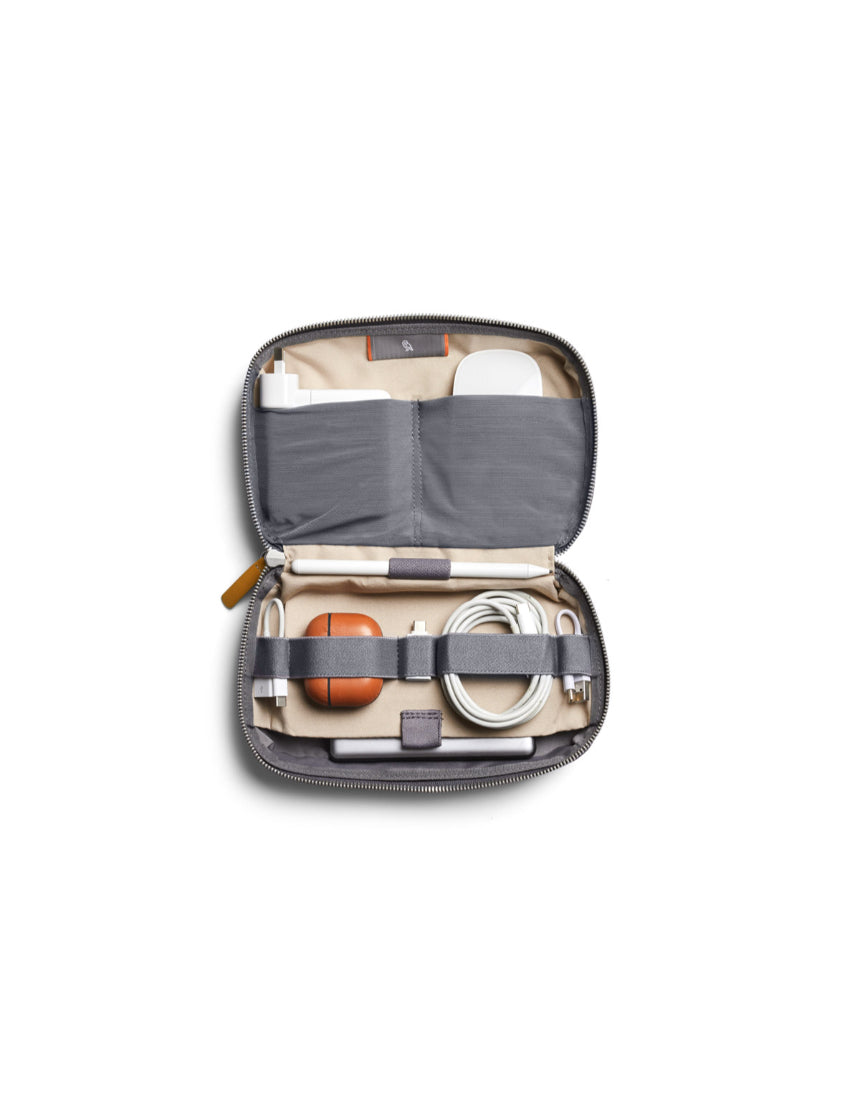 Bellroy Tech Kit in slate color, showing organized interior with multiple compartments for cables, chargers, and accessories.