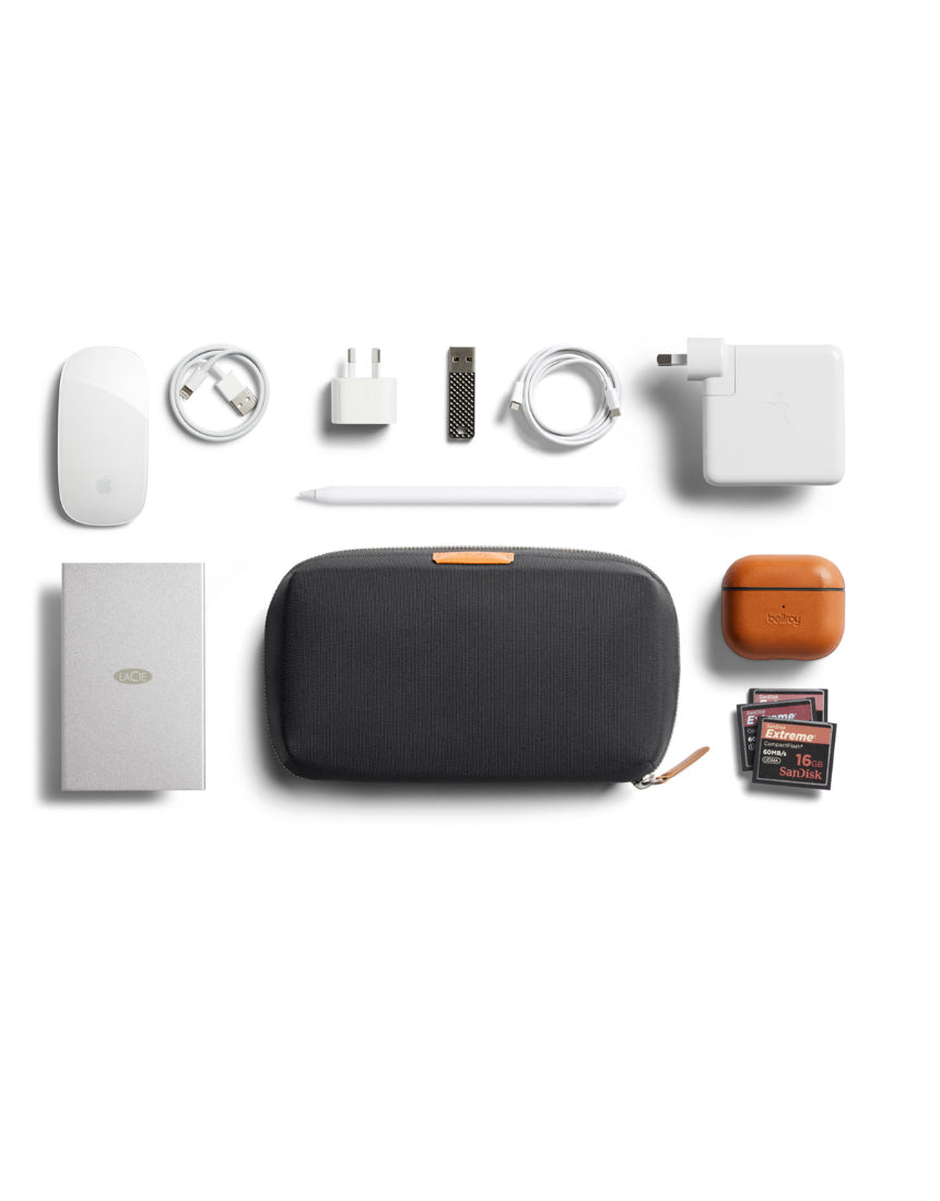 Bellroy Tech Kit in Slate showing organized compartments with cables, chargers, and electronic accessories inside.