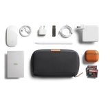 Bellroy Tech Kit in Slate showing organized compartments with cables, chargers, and electronic accessories inside.