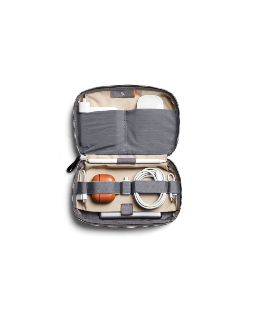 Bellroy Tech Kit in eucalyptus color showing organized compartments with cables and accessories inside.