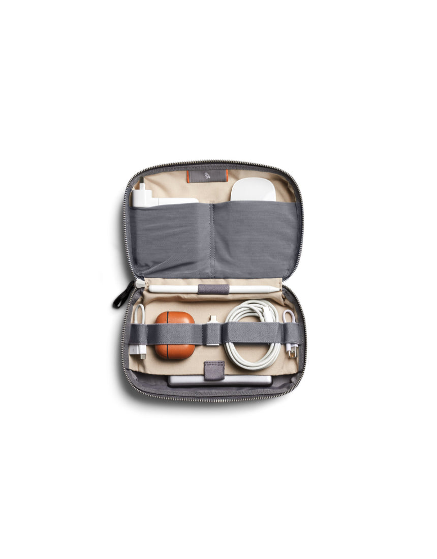 Bellroy Tech Kit in eucalyptus color showing organized compartments with cables and accessories inside.