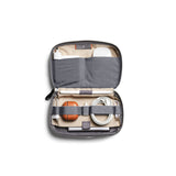 Bellroy Tech Kit in eucalyptus color showing organized compartments with cables and accessories inside.