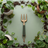 Green We The Wild hand fork garden tool with ergonomic handle, ideal for planting and cultivating in the garden.