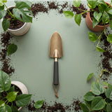 Green We The Wild hand trowel, a durable garden tool with a comfortable handle, perfect for planting and gardening tasks.