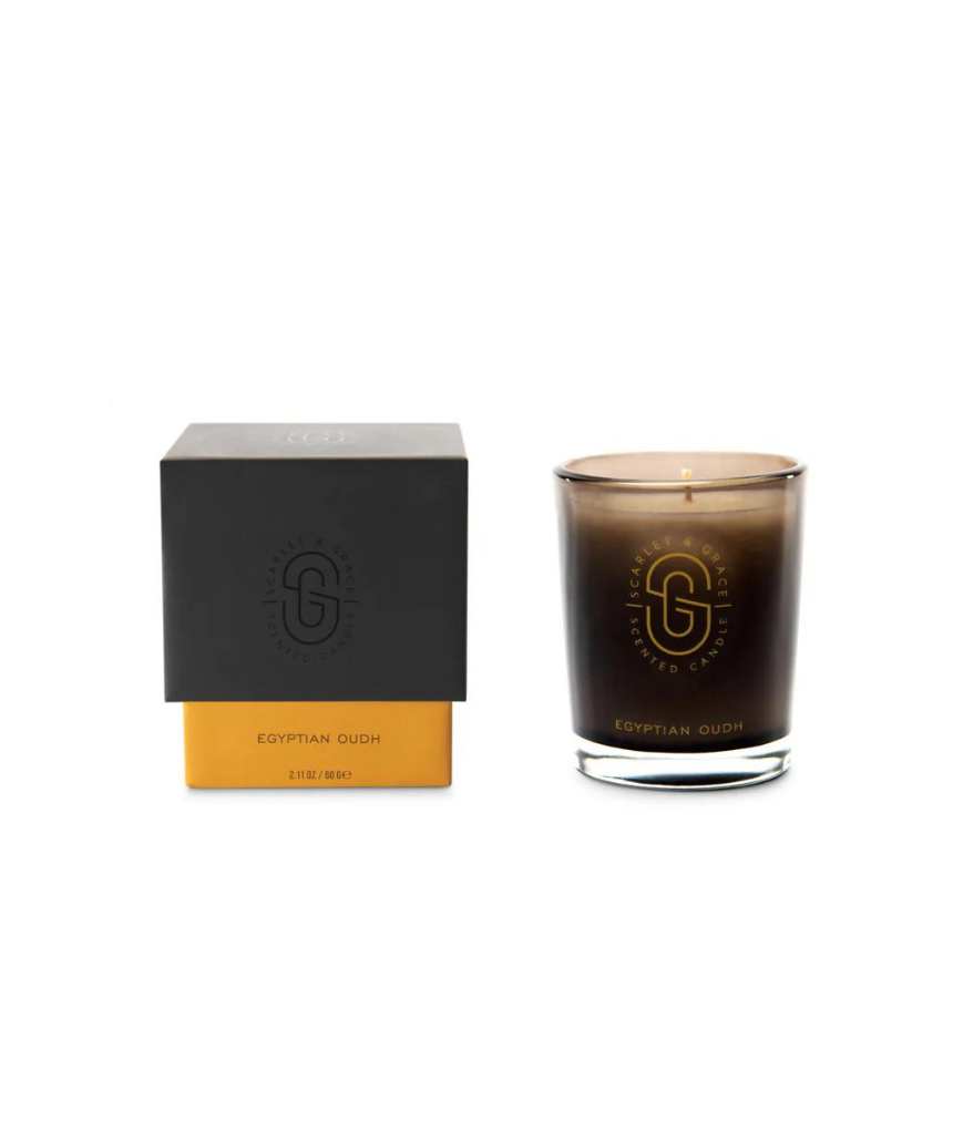 Scarlet & Grace Egyptian Oudh candle with a sleek black container, emitting warm, inviting light and rich oriental fragrance.