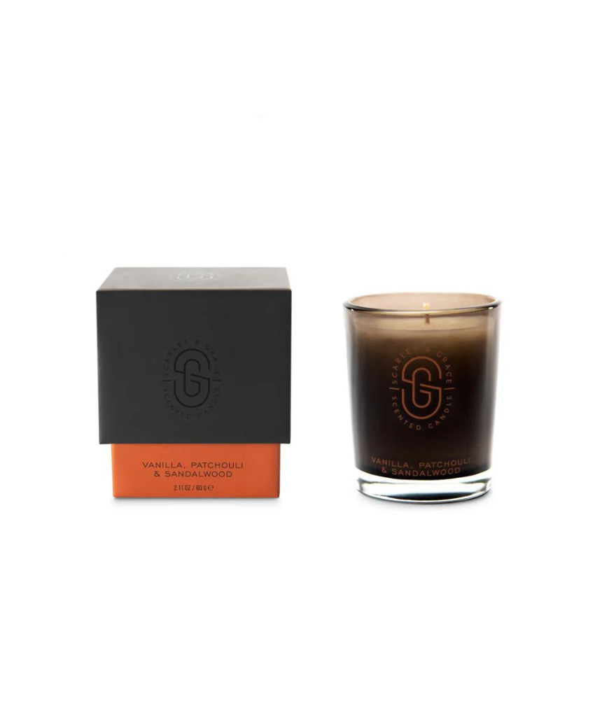 Scarlet & Grace vanilla, patchouli, sandalwood candle in 60g jar with a lit wick and a soft glow.