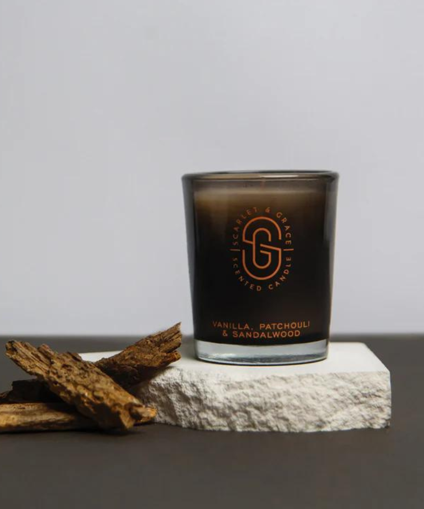 Scarlet & Grace vanilla, patchouli, and sandalwood scented candle in a 60g jar with a lit wick and elegant packaging.