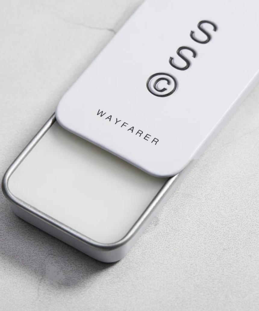 Solid State Wayfarer solid cologne in a sleek container, ready to be applied for a fresh, masculine scent.