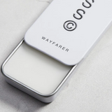 Solid State Wayfarer solid cologne in a sleek container, ready to be applied for a fresh, masculine scent.