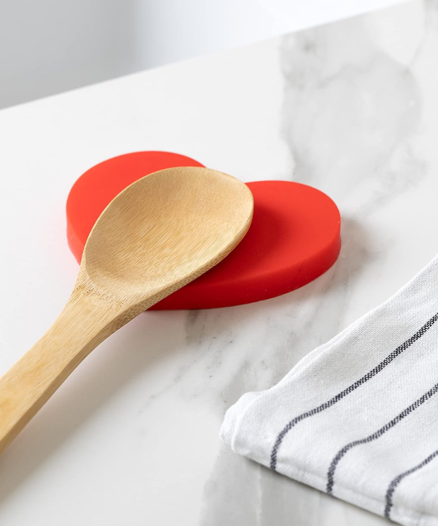 Fisura Heart-shaped spoon rest with a smooth ceramic finish, designed to hold and protect kitchen utensils during cooking.