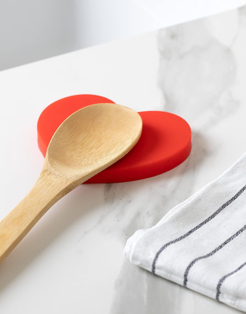 Fisura Heart-shaped spoon rest with a smooth ceramic finish, designed to hold and protect kitchen utensils during cooking.