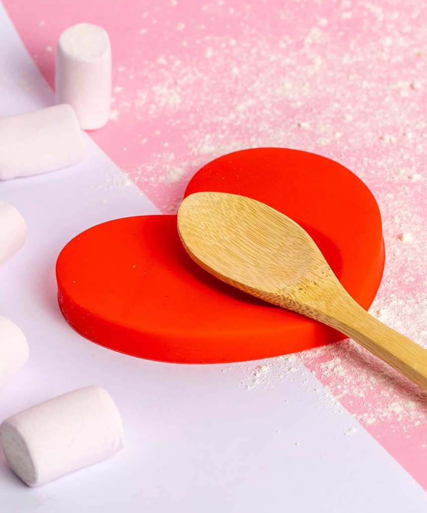 Fisura Heart-shaped spoon rest in ceramic with a smooth, glossy finish, designed to hold cooking spoons and prevent messes.