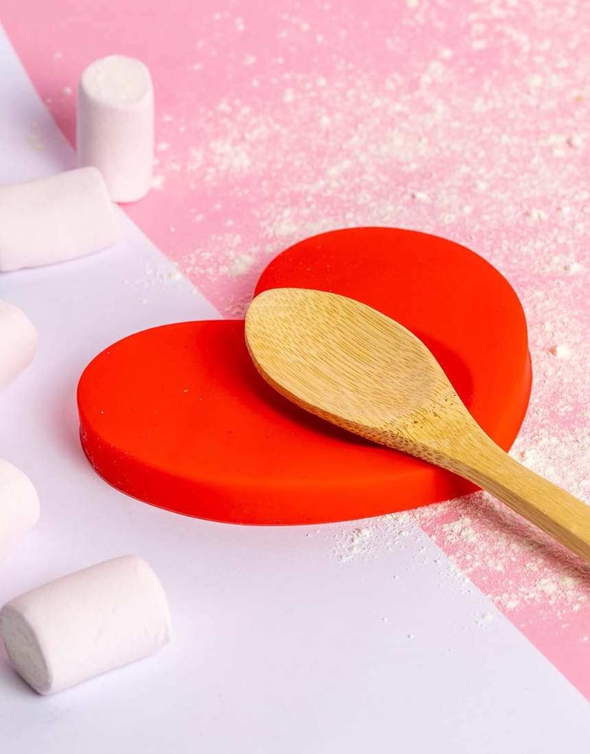 Fisura Heart-shaped spoon rest in ceramic with a smooth, glossy finish, designed to hold cooking spoons and prevent messes.
