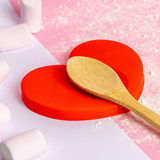 Fisura Heart-shaped spoon rest in ceramic with a smooth, glossy finish, designed to hold cooking spoons and prevent messes.