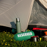 Fisura Grass Cushion labeled "reserved" with green grass design, soft fabric, and plush filling for comfortable seating.