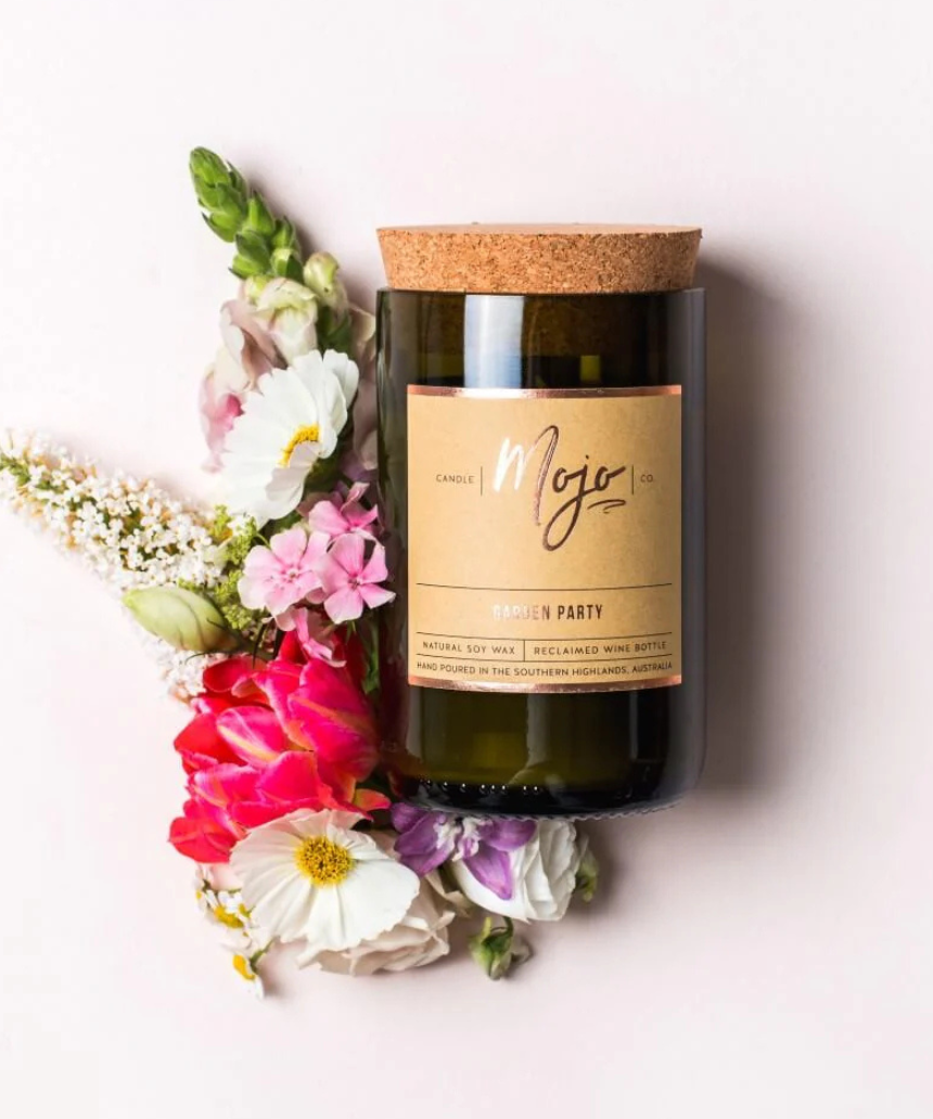 Mojo Candle Co. Garden Party candle with floral design and warm glow, showcasing a beautifully crafted aromatic candle.
