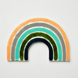 Jones & Co Golden Rainbow Pink wall decor featuring a vibrant rainbow design on a decorative wall hanging.