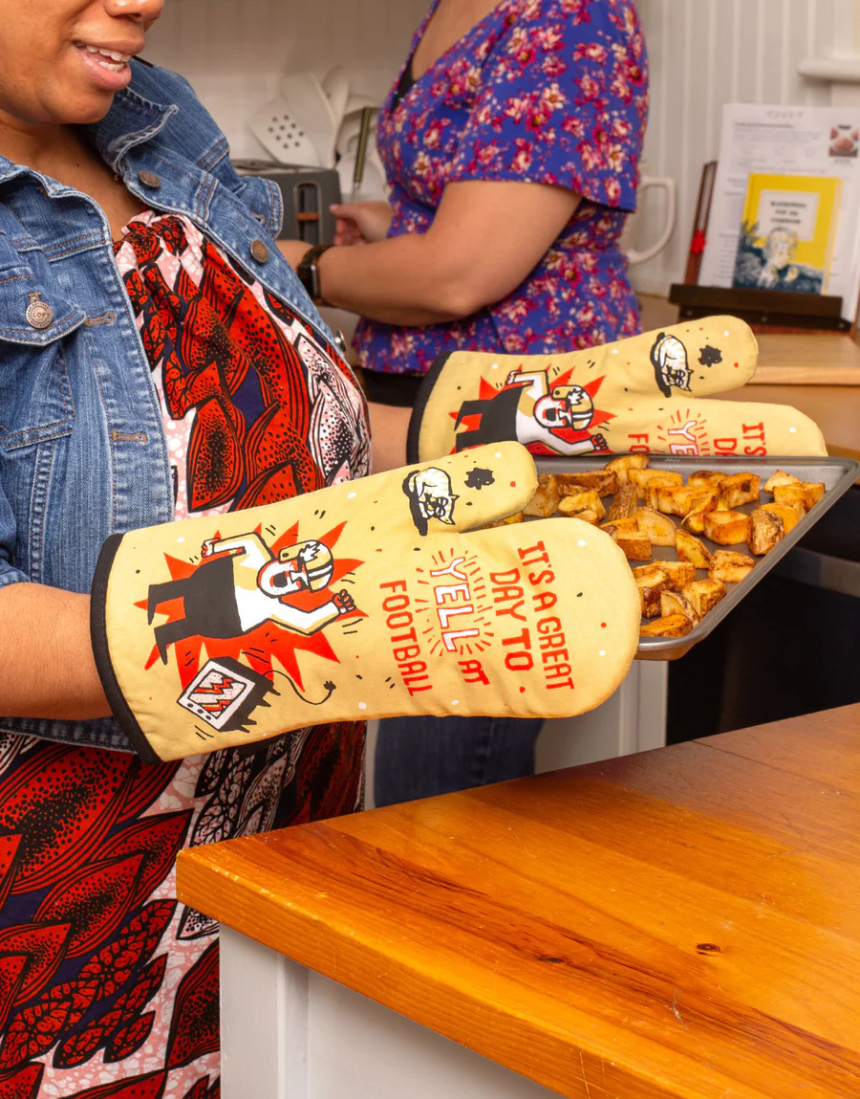 Blue Q Yell at Football oven mitt in bright blue with bold black and white football-themed design, heat-resistant kitchen accessory.
