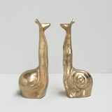 White Moose snail-shaped gold bookends with a sleek, modern design for organizing books on a shelf.