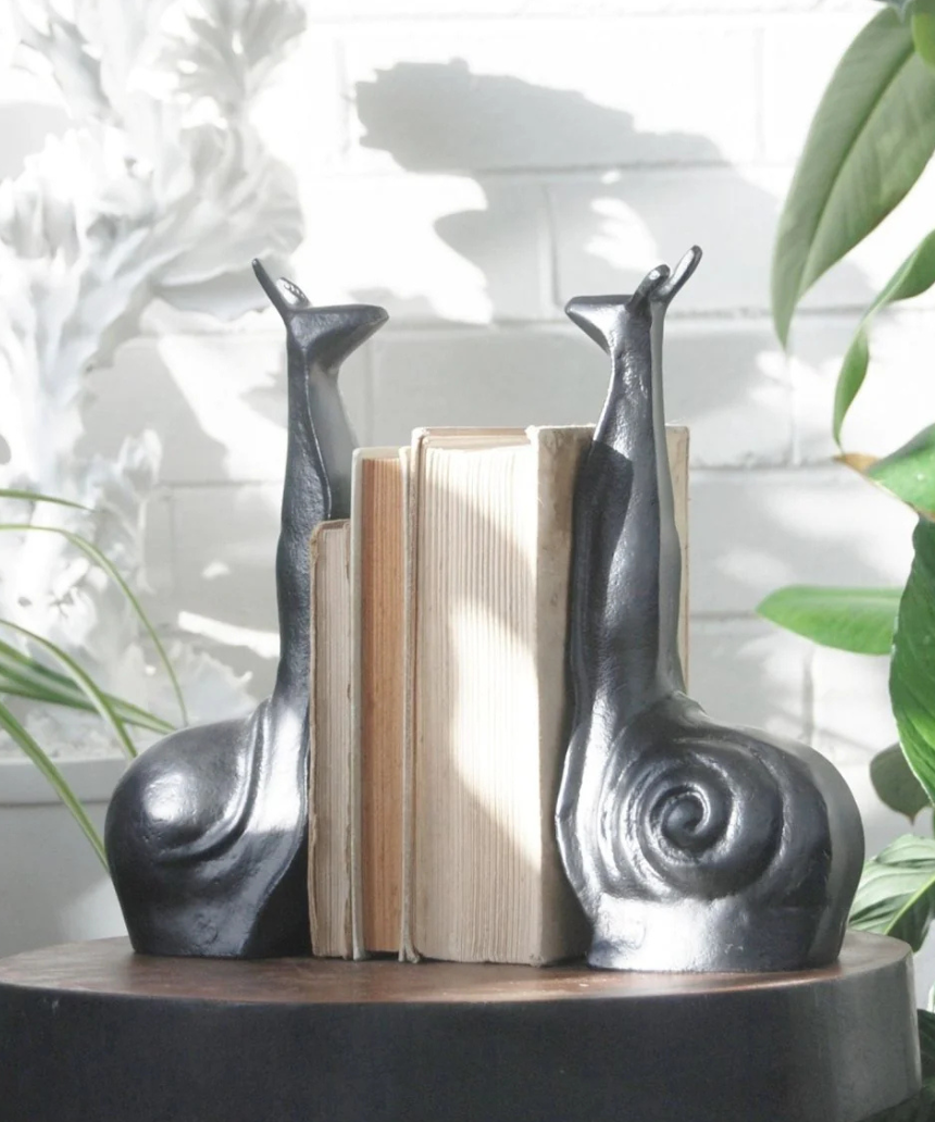 White Moose snail-shaped black bookends, decorative and functional for holding books upright on a shelf.