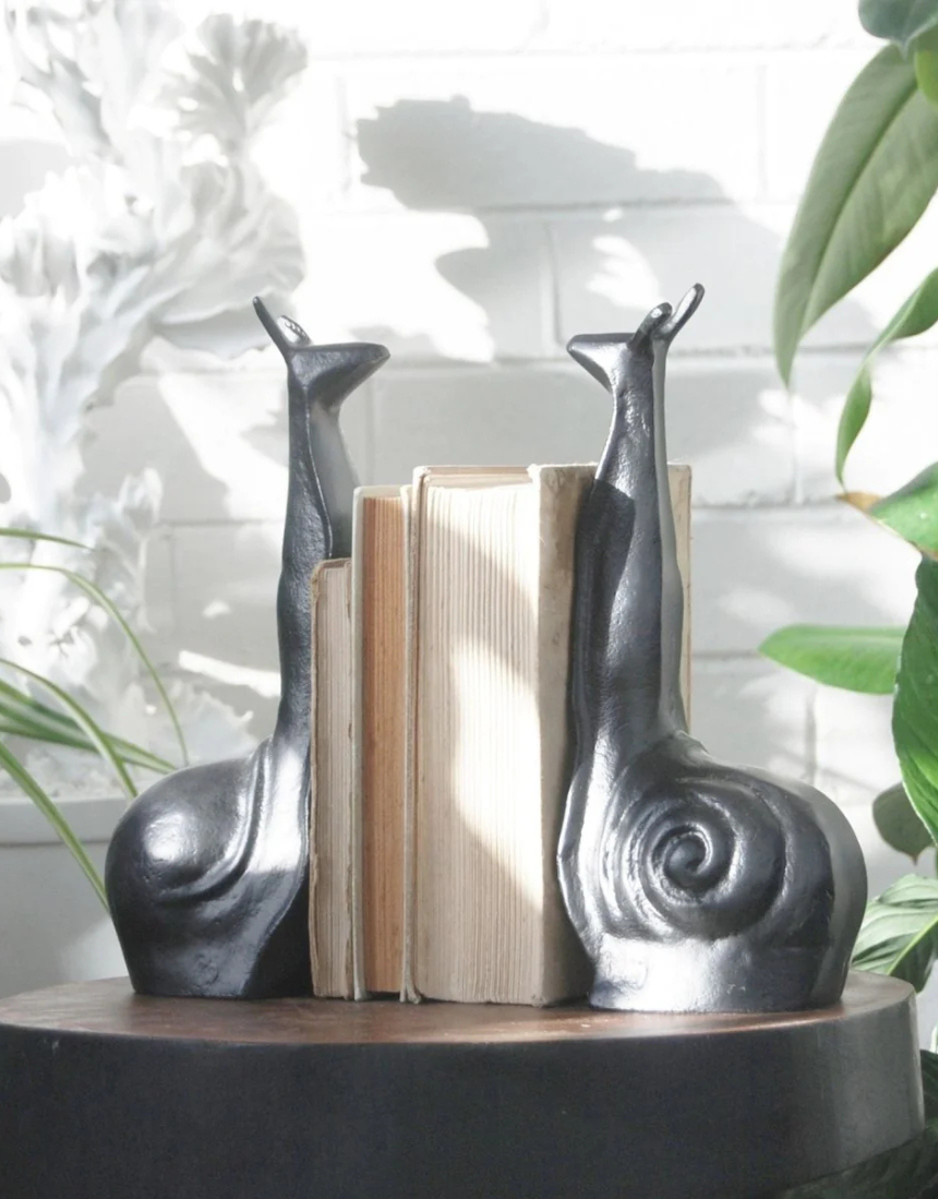 White Moose snail-shaped black bookends, decorative and functional for holding books upright on a shelf.
