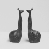White Moose snail-shaped black bookends on a shelf, decorative and functional for holding books upright.