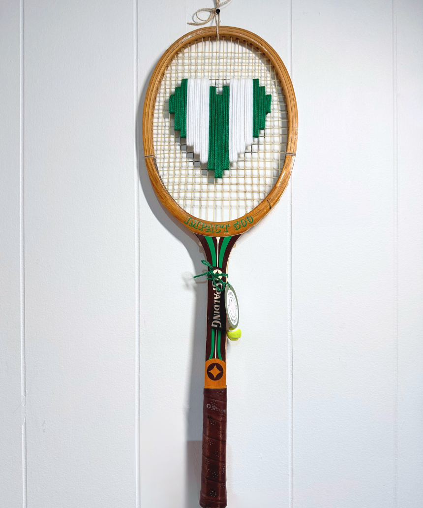 What A Racquet! green and white heart-shaped tennis racquet with a decorative handle design.