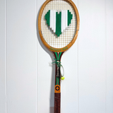 What A Racquet! green and white heart-shaped tennis racquet with a decorative handle design.