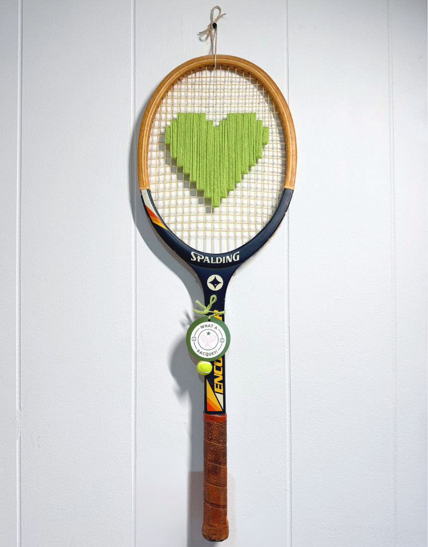 Apple green heart-shaped tennis racquet by What A Racquet! with a sleek, vibrant design and a comfortable grip.