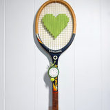 Apple green heart-shaped tennis racquet by What A Racquet! with a sleek, vibrant design and a comfortable grip.