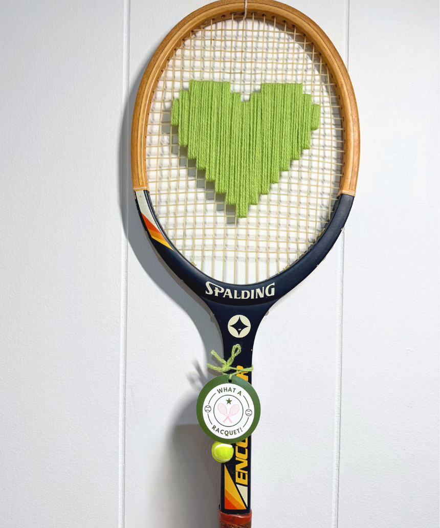 Apple green heart-shaped racquet from What A Racquet! with a sleek design and smooth handle on a white background.