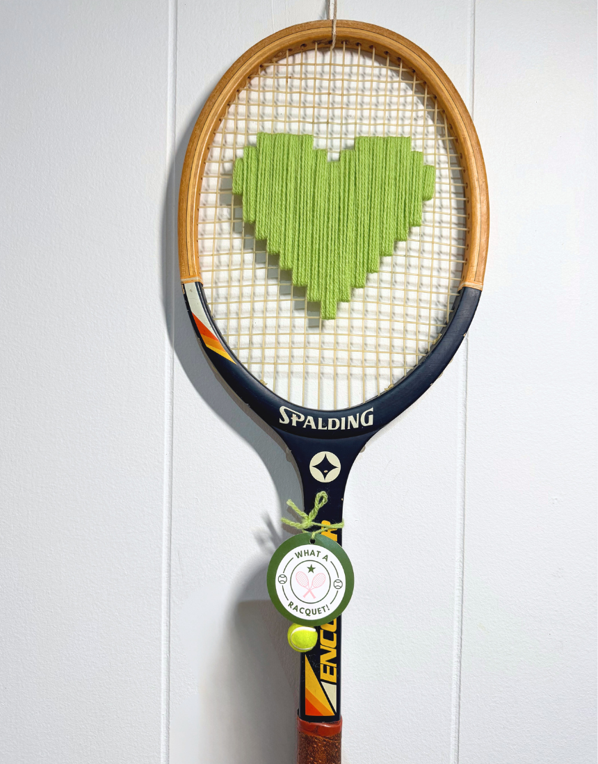 Apple green heart-shaped racquet from What A Racquet! with a sleek design and smooth handle on a white background.