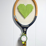 Apple green heart-shaped racquet from What A Racquet! with a sleek design and smooth handle on a white background.